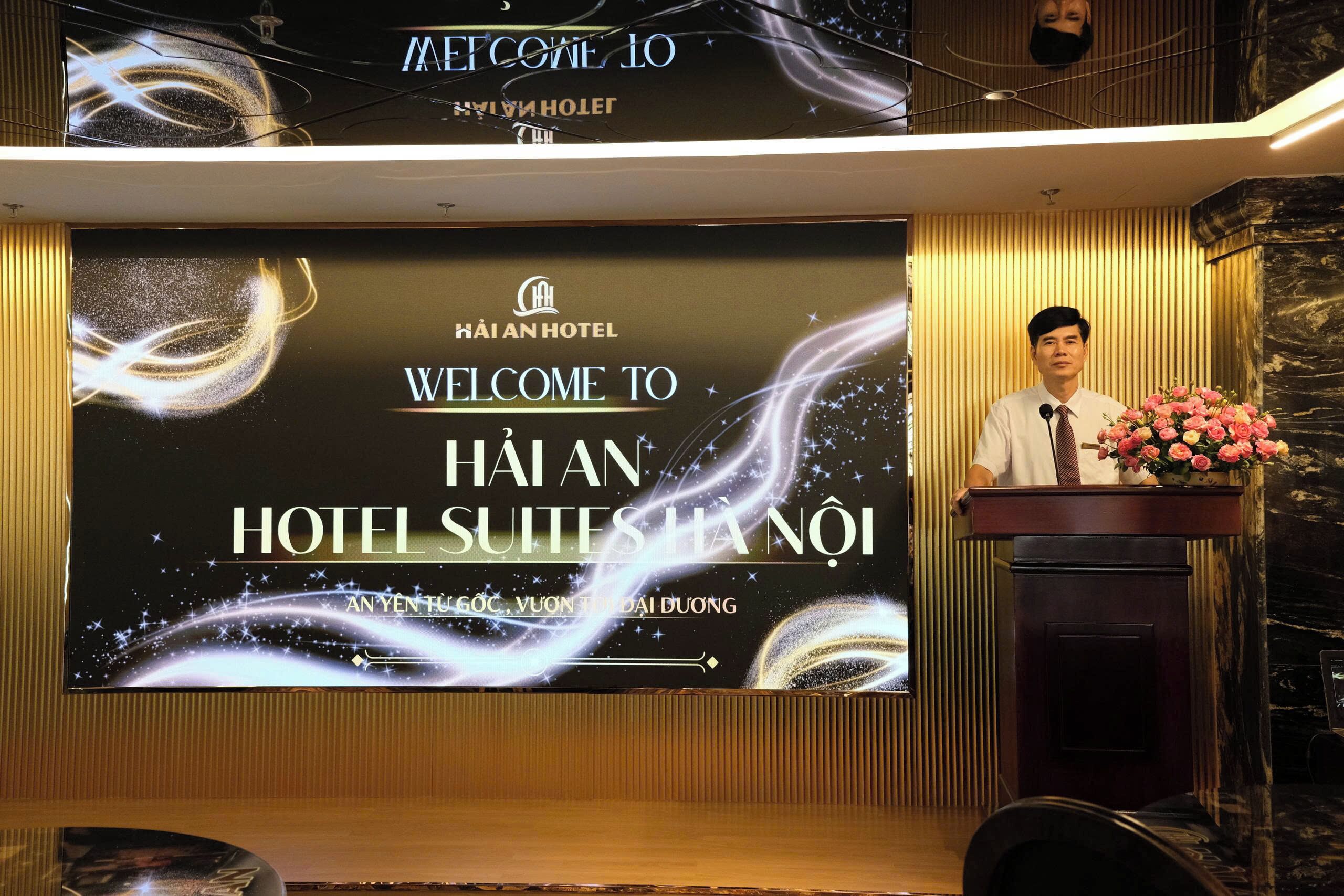 A hotel reception area with a large screen displaying the hotel's name and a welcome message.