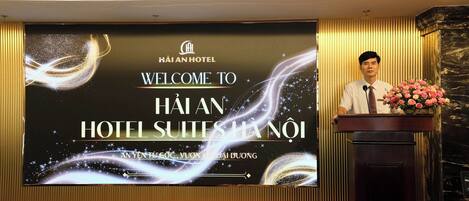 A hotel reception area with a large screen displaying the hotel's name and a welcome message.