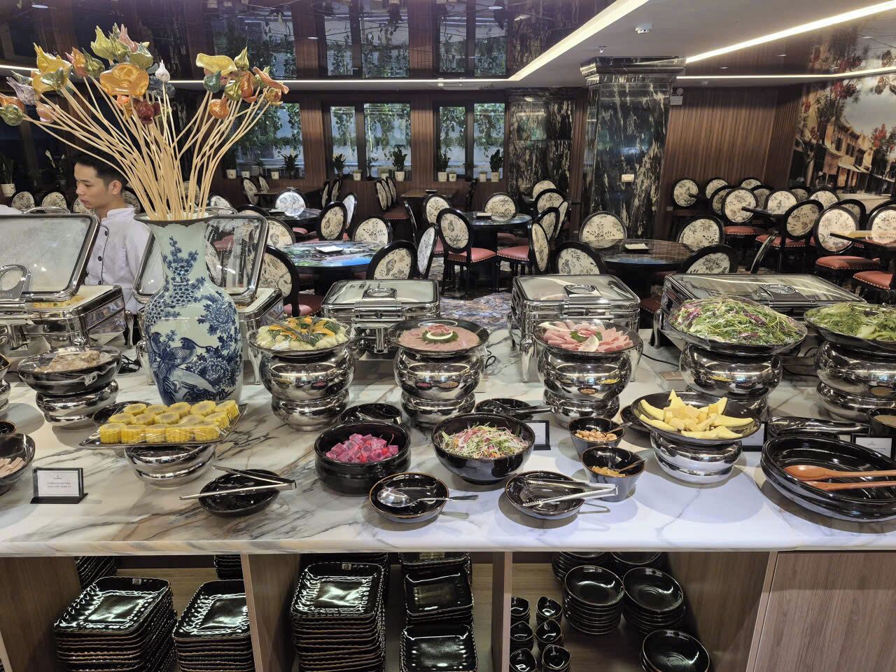 A buffet with various dishes and a decorative vase.