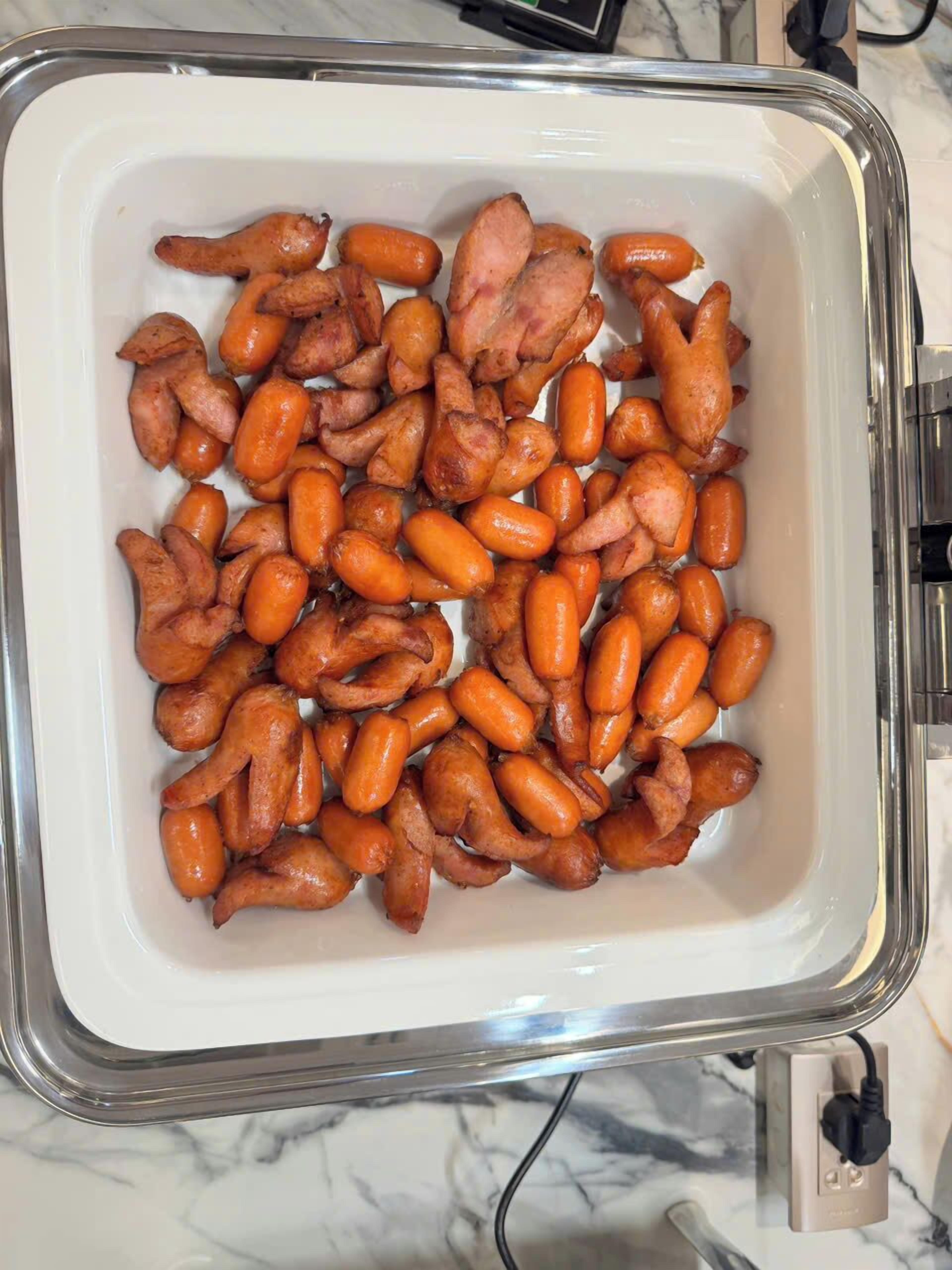 A tray of cooked chicken wings and carrots.