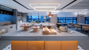 A modern kitchen with a central island, built-in appliances, and a view of the cityscape. - Zhangjiajie Homeinn Plus Hotel (Zhangjiajie)