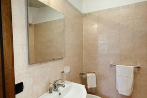 Ein Badezimmer mit Waschbecken, Spiegel und Handtuchhalter.