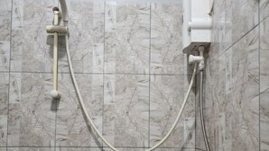A shower with a handheld showerhead and a wall-mounted control unit. - Puspita Homestay Mitra RedDoorz (Pondok Melati)