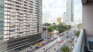 A high-rise building with a grid-like facade and multiple windows. - Comfy condo. Best location on Shaw Blvd, front of Shang Mall. Short walk to SM. (Mandaluyong City)