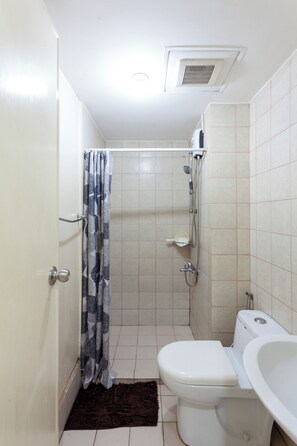 A small bathroom with a toilet, shower, and bathtub. - Comfy condo. Best location on Shaw Blvd, front of Shang Mall. Short walk to SM. (Mandaluyong City)