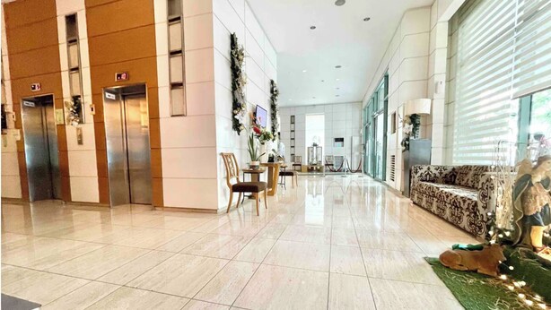 A spacious lobby with a polished tile floor, a reception desk, and a seating area with patterned upholstery. - Comfy condo. Best location on Shaw Blvd, front of Shang Mall. Short walk to SM. (Mandaluyong City)