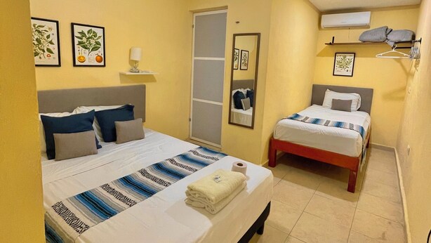Habitación de hotel con dos camas, un espejo grande y obras de arte en las paredes.