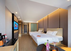 A hotel room with two beds, a TV, a minibar, and a small table with a bottle and a glass. - Zhangjiajie Hero Boutique Hotel (Zhangjiajie)