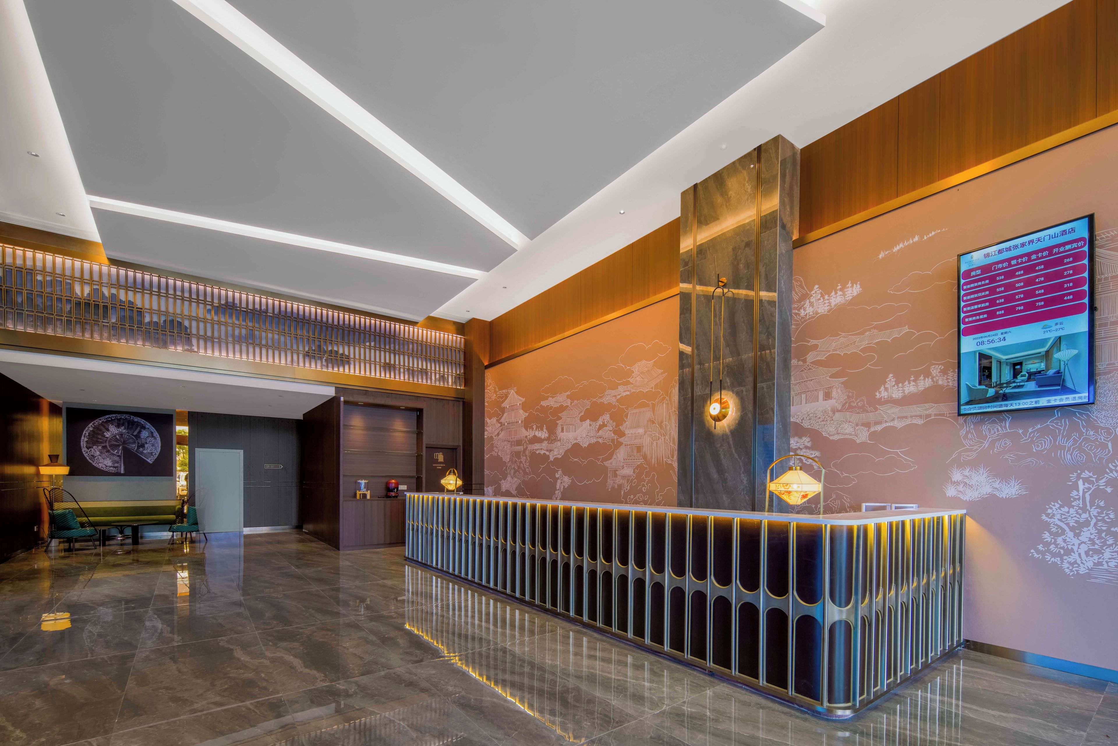 A modern hotel lobby with a reception desk, a seating area, and a high ceiling with lighting.