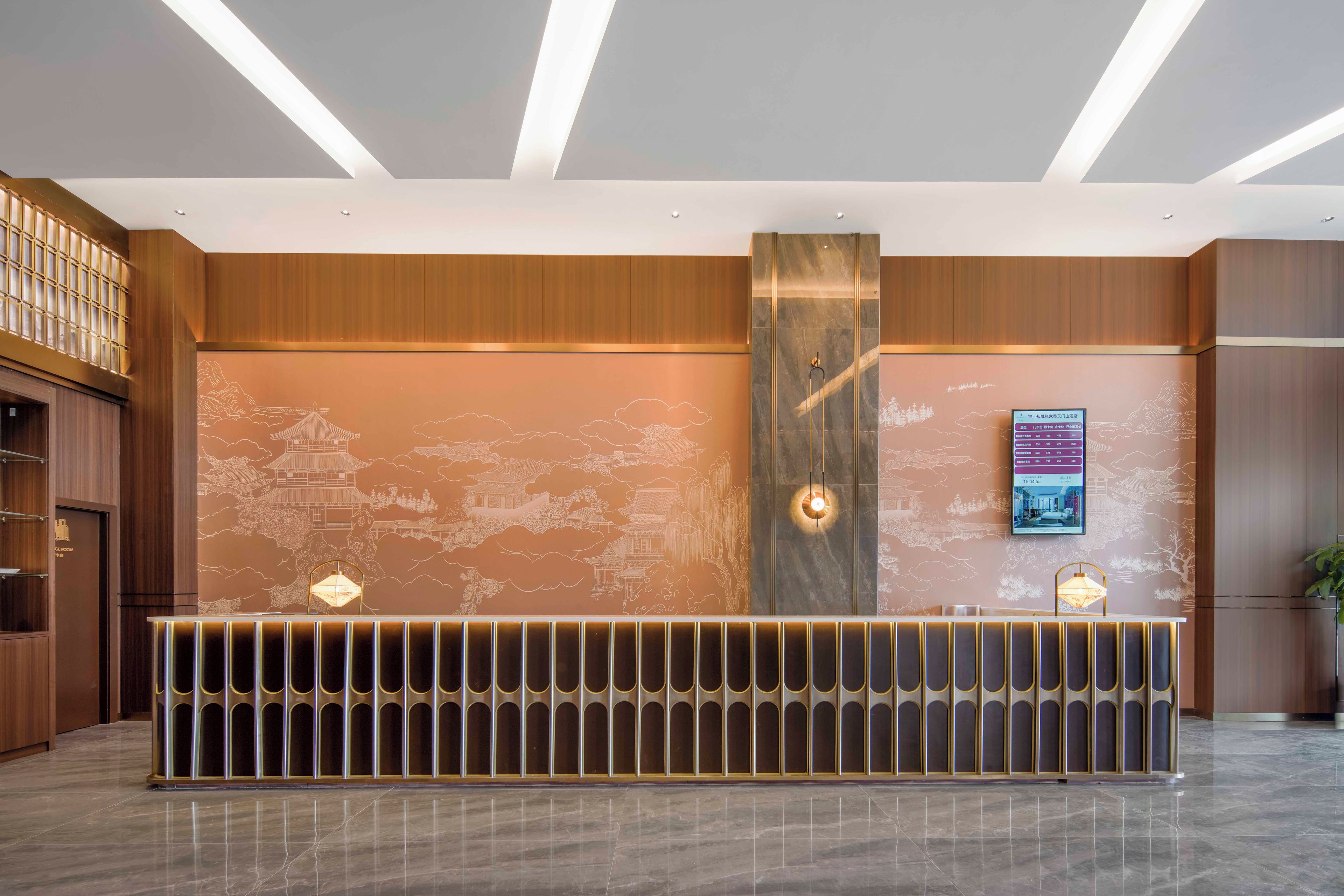 A reception desk with a modern design, a digital display, and a traditional mural.