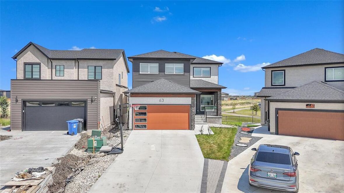 Un quartier résidentiel comprenant trois maisons, chacune dotée d’un garage et d’une allée.