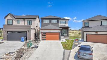 Un quartier résidentiel comprenant trois maisons, chacune dotée d’un garage et d’une allée.