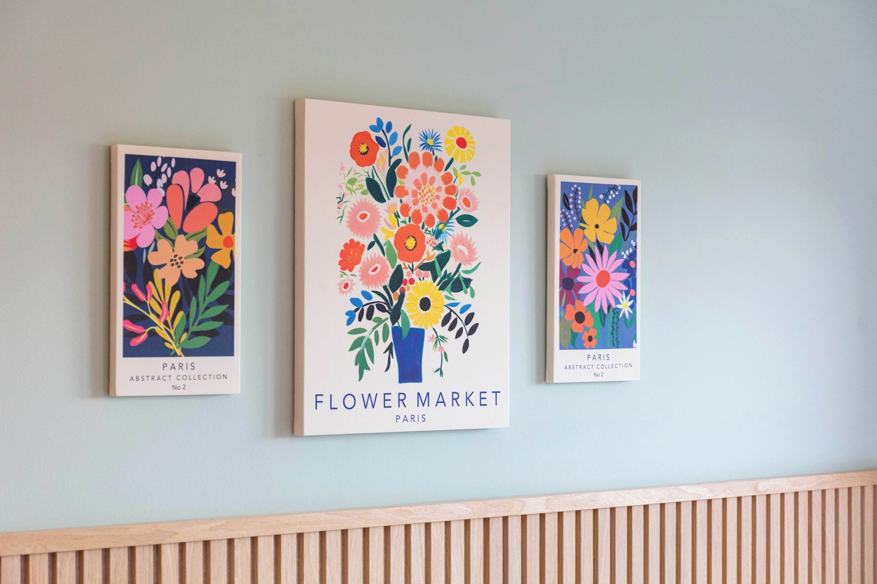 Drei gerahmte Kunstwerke mit dem Titel 'Flower Market Paris' an einer Wand.