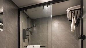 A modern bathroom with a glass-enclosed shower, a toilet, and a towel rack with towels. - Ha Fa Villa  (Hong Kong Island)