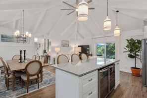A spacious kitchen with a large island, pendant lights, and a ceiling fan. - Dog Friendly, Hot Tub, & Walk to Beach! (Southern Shores)