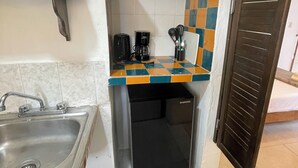 A compact kitchen with a sink, a coffee maker, and a small refrigerator. - Downtown Studio for 3 w Kitchen (Isla Mujeres)