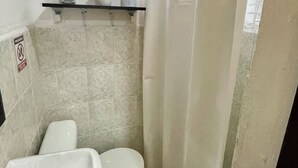 A small bathroom with a toilet, sink, and tiled walls. - Downtown Studio for 3 w Kitchen (Isla Mujeres)