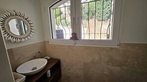 A bathroom with a round sink, a decorative mirror, and a window with metal bars. - Master villa for 14 people with air conditioning (LES ISSAMBRES)