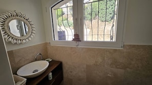 A bathroom with a round sink, a decorative mirror, and a window with metal bars. - Master villa for 14 people with air conditioning (LES ISSAMBRES)