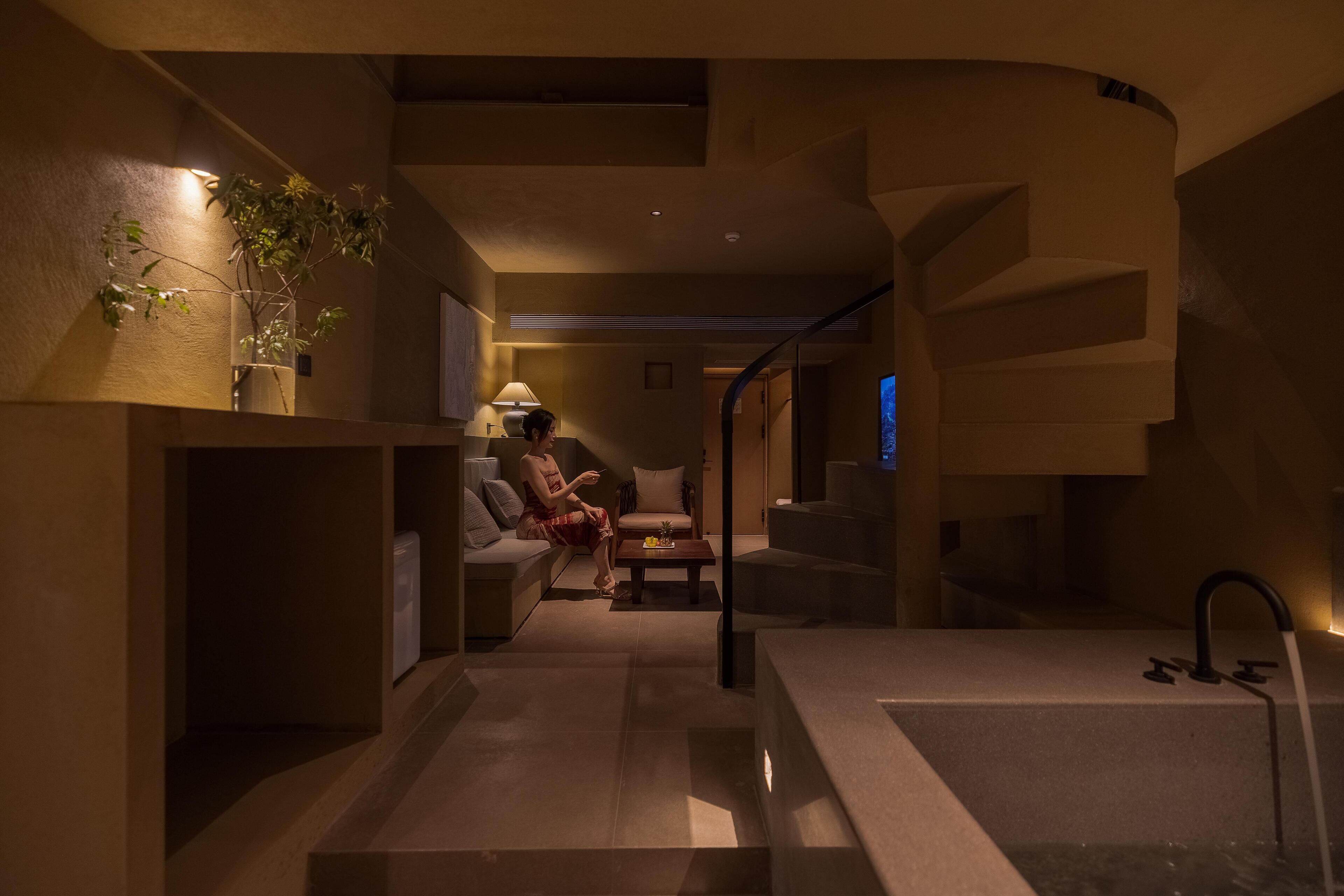 Een modern interieur met een bank, een bijzettafeltje en een trap.