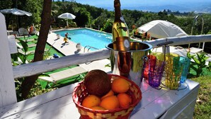 A poolside setting with a bottle of champagne, a bucket, and a basket of oranges. - Dream Tuscany (Toscana)
