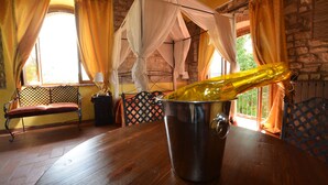 A room with a wooden table, a metal bucket with a bottle, a bench, and a window with curtains. - Dream Tuscany (Toscana)
