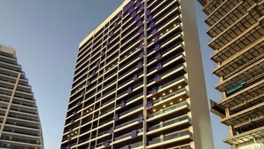 Un moderno hotel grattacielo con numerosi balconi, un pavimento dal design decorativo e una zona piscina.