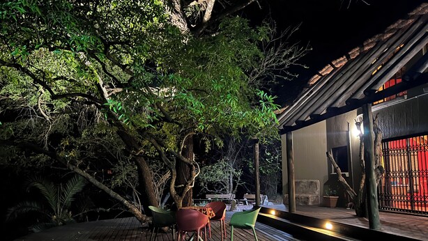 An outdoor deck with wooden flooring, a hot tub, and a table with chairs. - Reverie Safari Lodge: Exclusive private lodge in Marloth Park (Marloth Park)