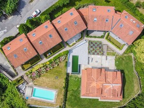 Vista aérea de una zona residencial con varias casas, una piscina y un jardín.