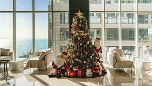 A modern hotel lobby with a large Christmas tree, plush seating, and a view of the sea. - Hotel Costa Siheung Geobuksum (Siheung)