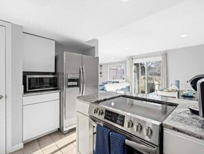 Una cocina moderna con electrodomésticos de acero inoxidable, horno empotrado y microondas.