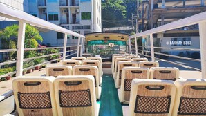 Interior de autobús con filas de asientos de madera y un pasillo central.