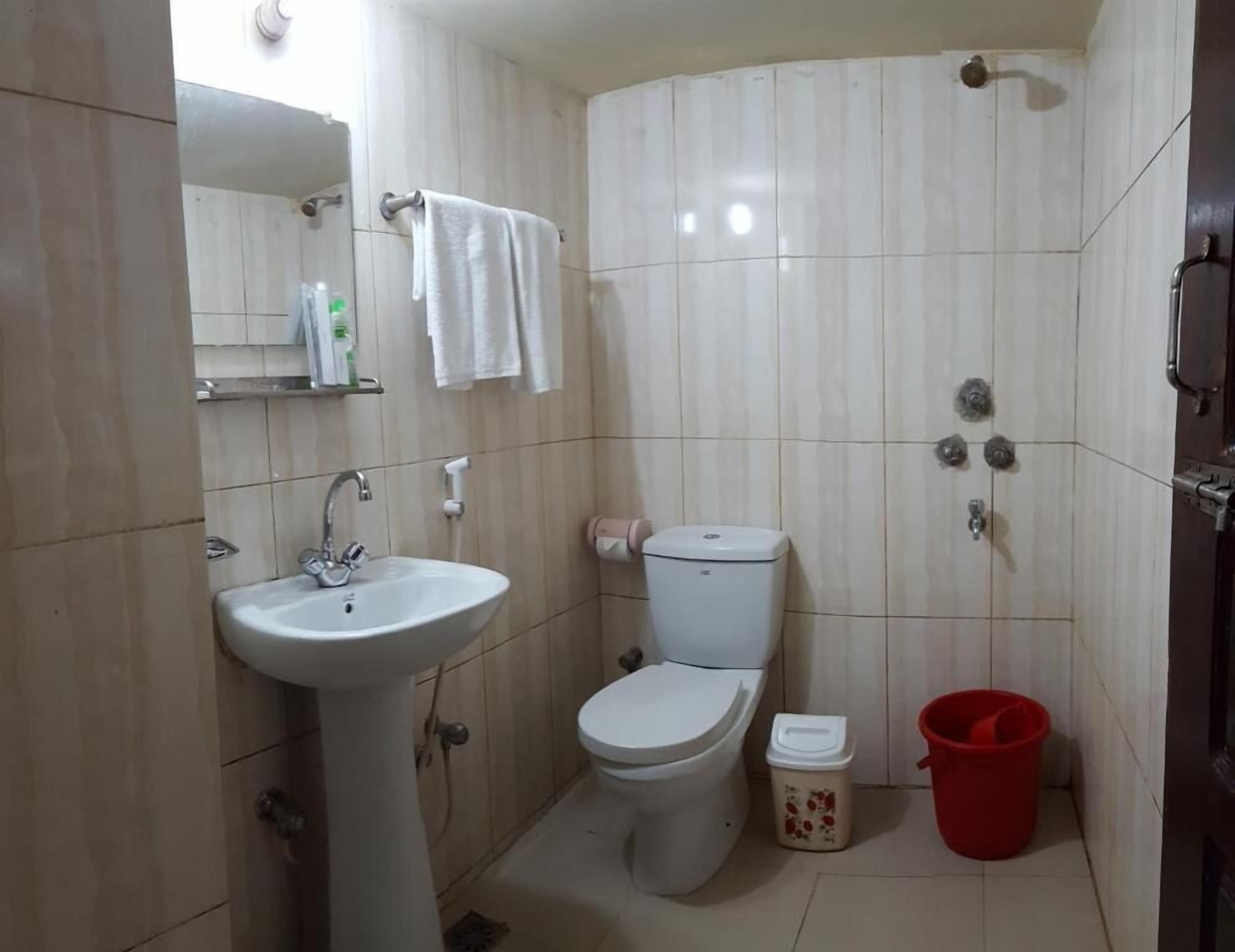Un baño con lavamanos, inodoro y ducha.