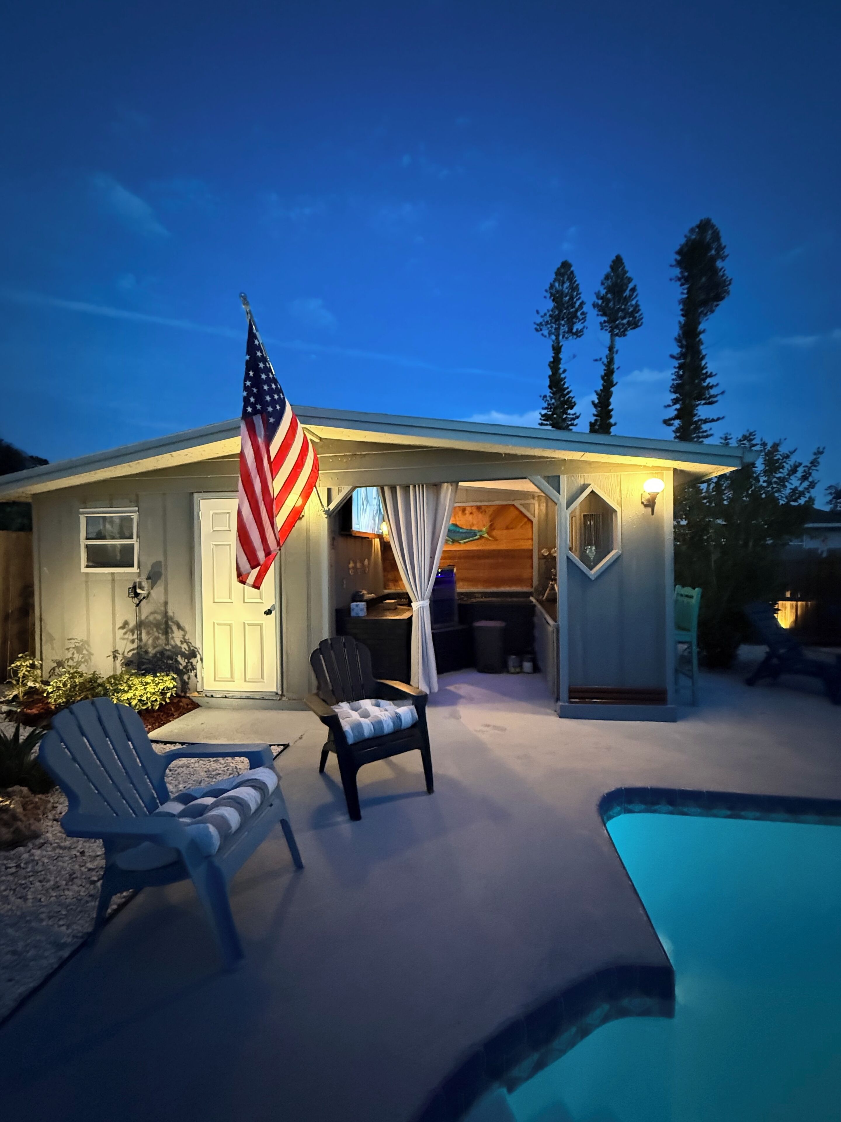 Ein Haus mit angebauter Garage, Pool und einer amerikanischen Flagge.