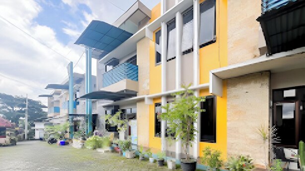 A row of modern buildings with balconies and potted plants. - Rumi Hotel (Malang)