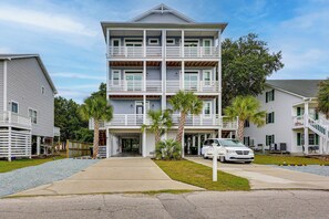 A multi-story residential building with a central entrance, balconies, and a car parked in front. - 2 Mi to Boardwalk! Coastal Carolina Beach Hideaway (Carolina Beach)