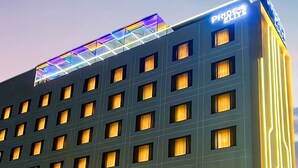 A hotel with a modern facade, multiple windows, and a prominent sign at the top. - Pride Elite Chhatrapati Sambhaji Nagar (Chhatrapati Sambhajinagar)