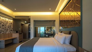 A modern hotel room with a large bed, a desk, and a view through a glass door. - Pride Elite Chhatrapati Sambhaji Nagar (Chhatrapati Sambhajinagar)