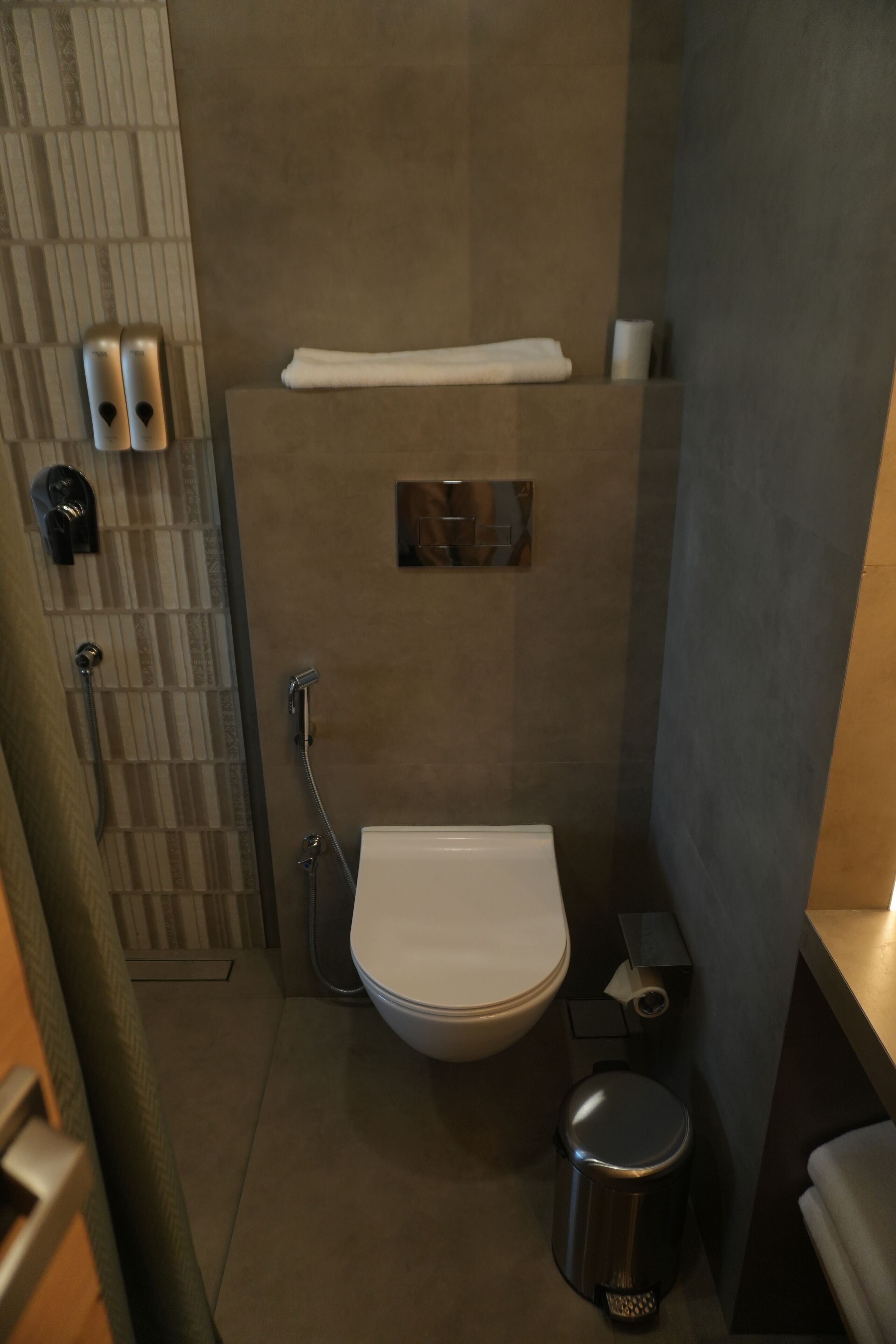 Une salle de bain moderne équipée de toilettes, d’un bidet et d’un sèche-mains.