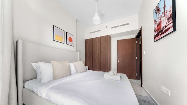 A modern hotel room with a large bed, a wardrobe, and a framed picture on the wall. - Stayshort - 1 Bed in Business Bay Sleeps 2 With City View (Dubai)