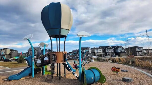A playground with a slide, climbing structures, and a hot air balloon playhouse. - Clean, Cozy, Comfy & Modern (Calgary)