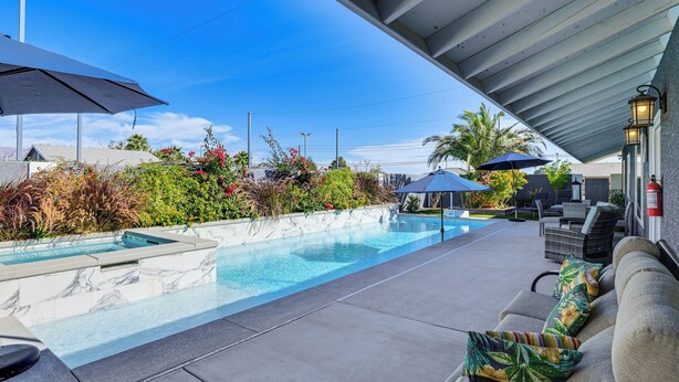 A swimming pool with a tiled deck, outdoor furniture, and umbrellas. - 7 Mi to Fremont St: Vegas Home w/ Backyard Oasis! (North Las Vegas)