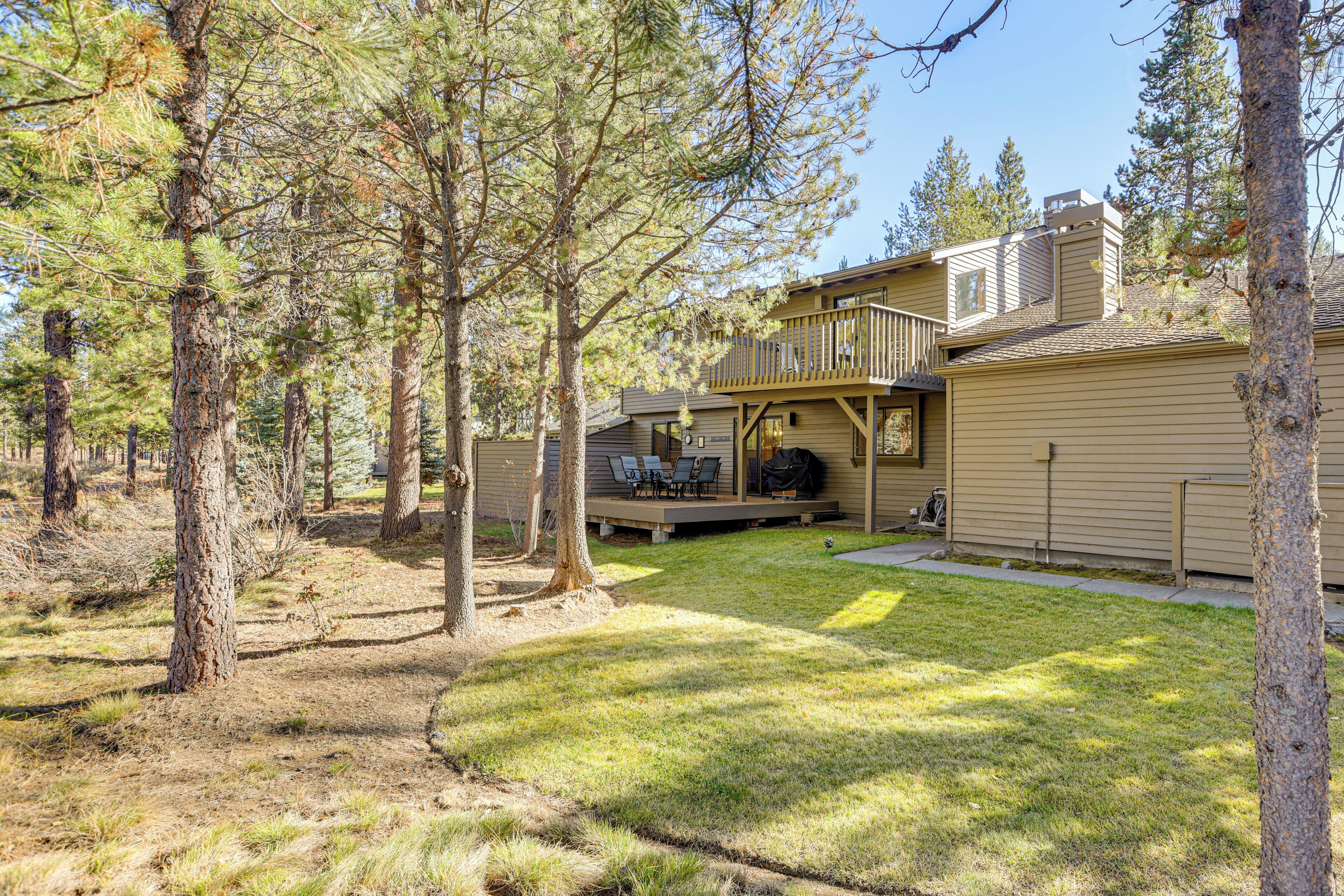 A two-story house with a deck, a barbecue area, and a covered patio.