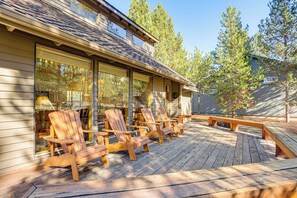 A wooden deck with Adirondack chairs and a bench, overlooking a forested area. - Private Hot Tub & SHARC Passes! Sunriver Home (Sunriver)