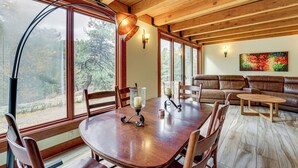 A wooden dining table with chairs, a wooden ceiling, and a sofa in a room with large windows. - Outdoor Lover's Paradise: Private Bayfield Escape (Bayfield)