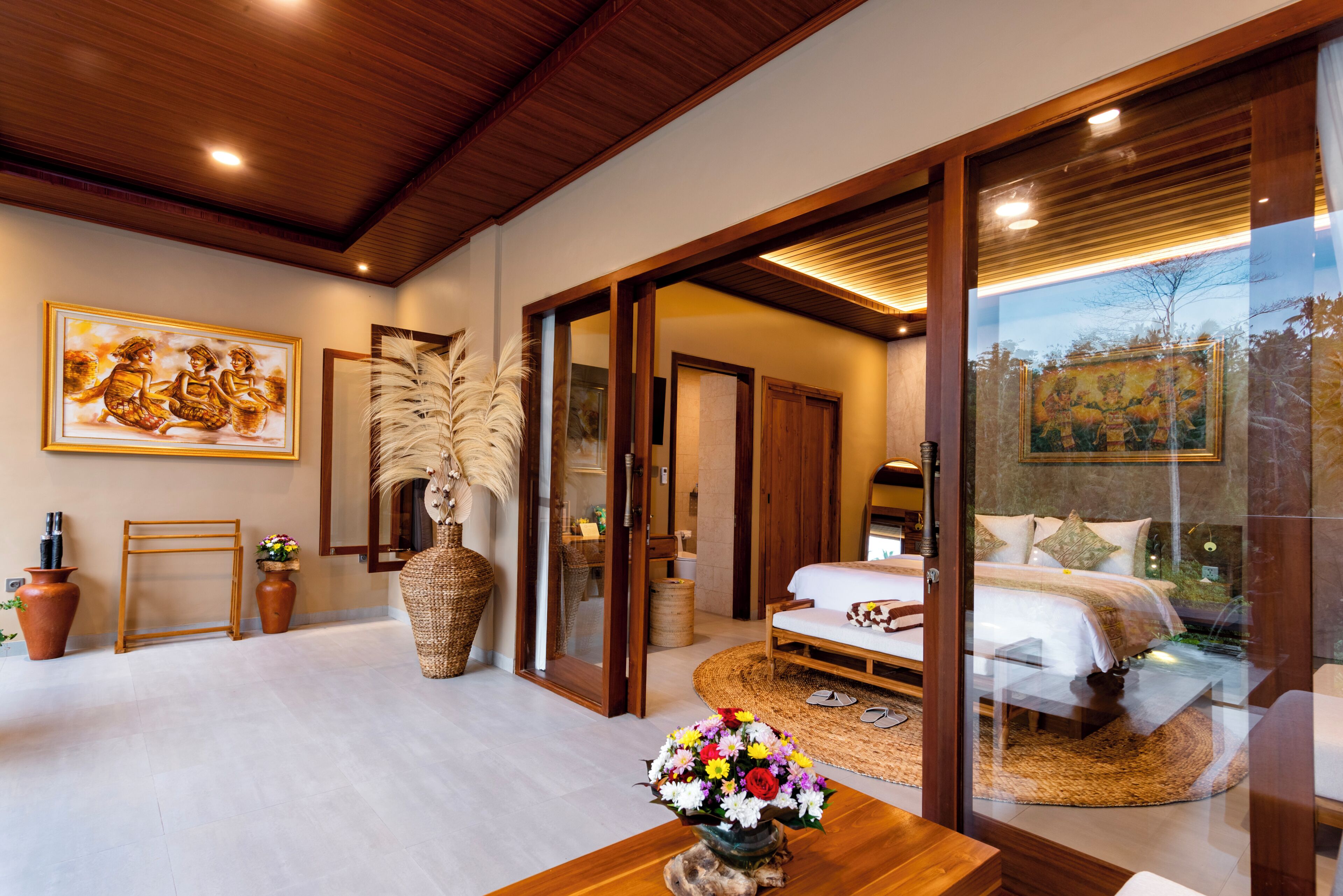 A modern bedroom with a large bed, a glass door leading to a balcony, and a wooden ceiling.