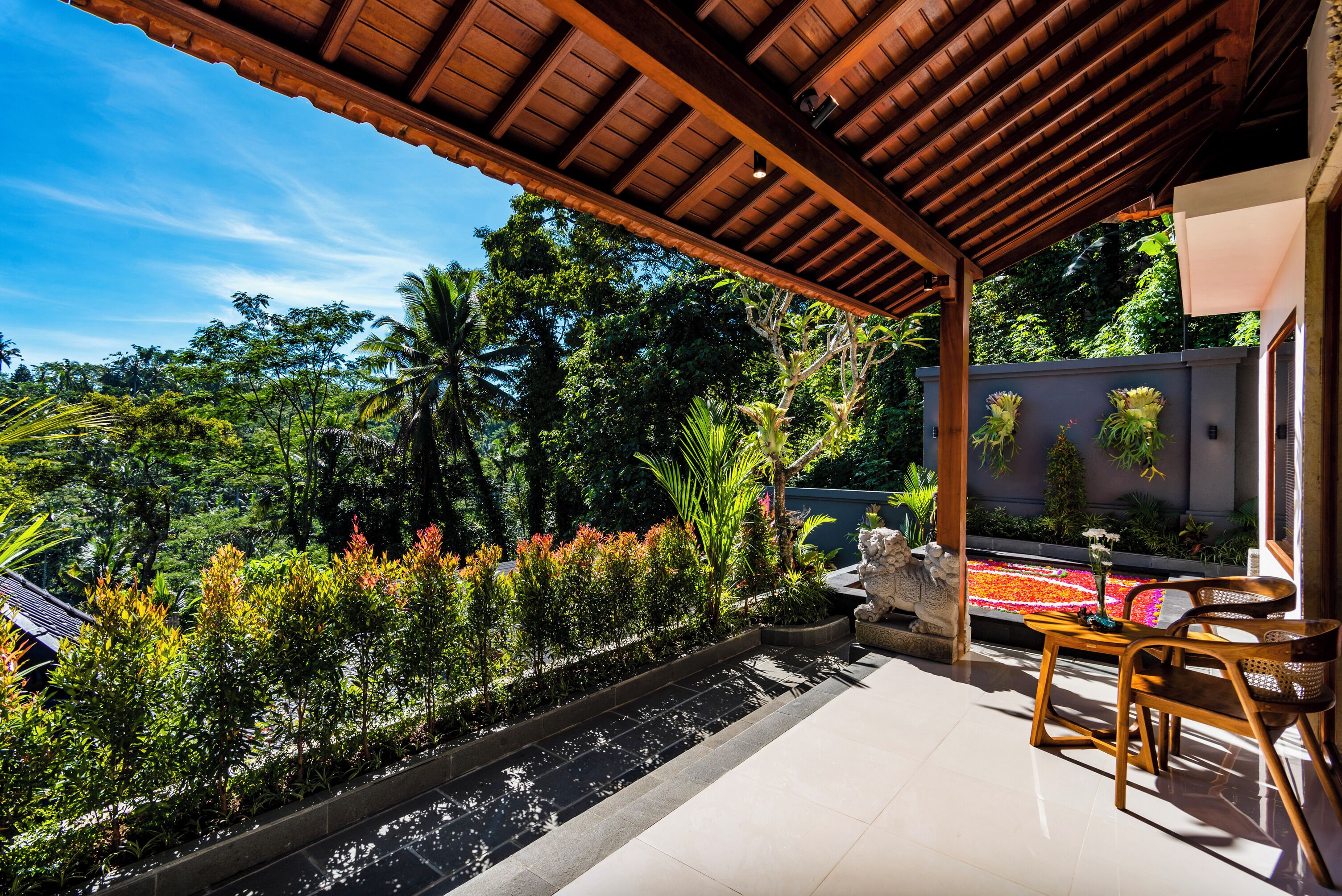 Un patio techado con vista a vegetación exuberante y un estanque de carpas.
