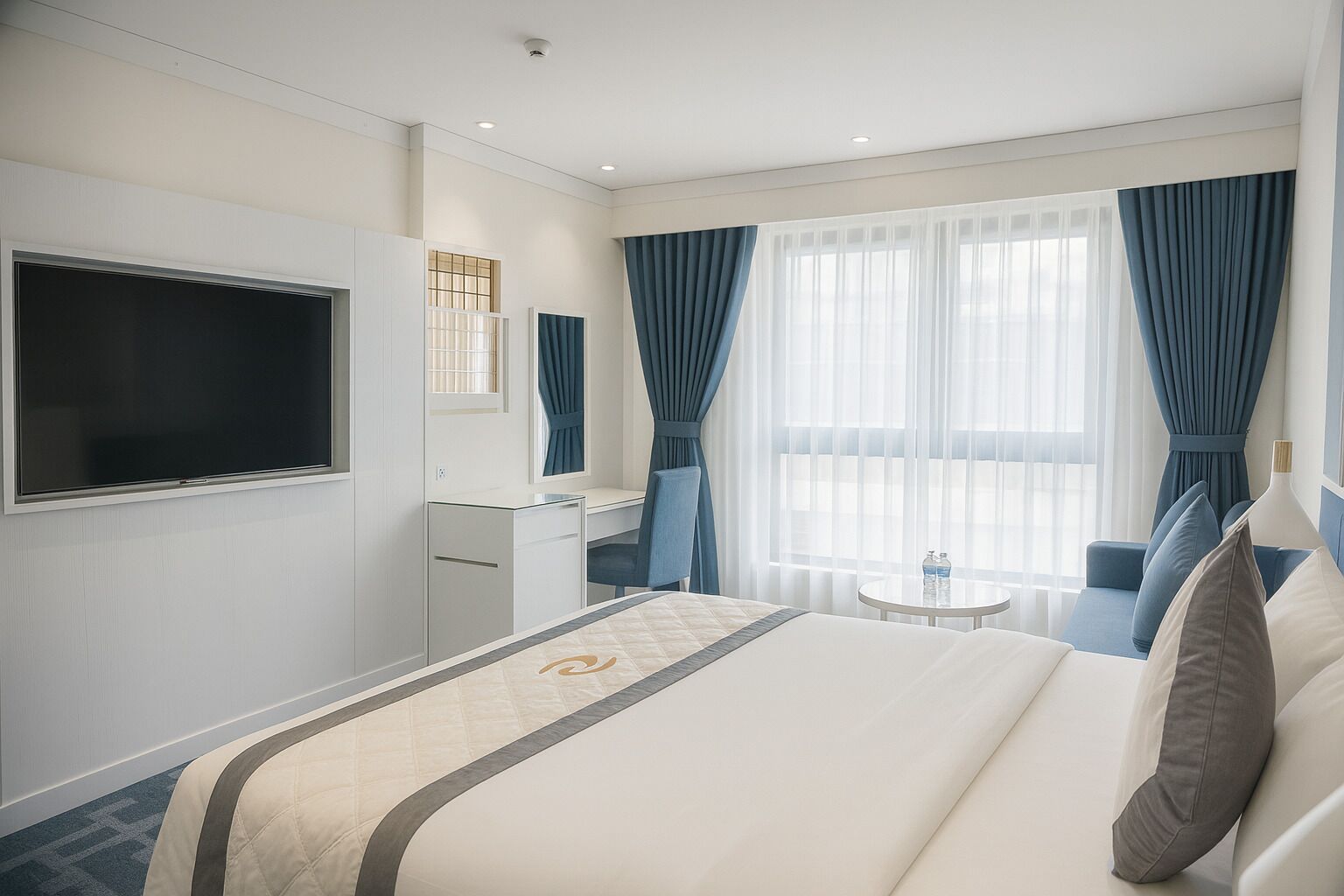 A hotel room with a bed, a desk, a chair, a TV, and a window with curtains.