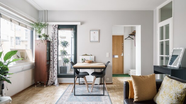 A compact living space with a dining area, a sofa, and a small table. - Bright Studio Apt. with Private Balcony  (Helsinki)