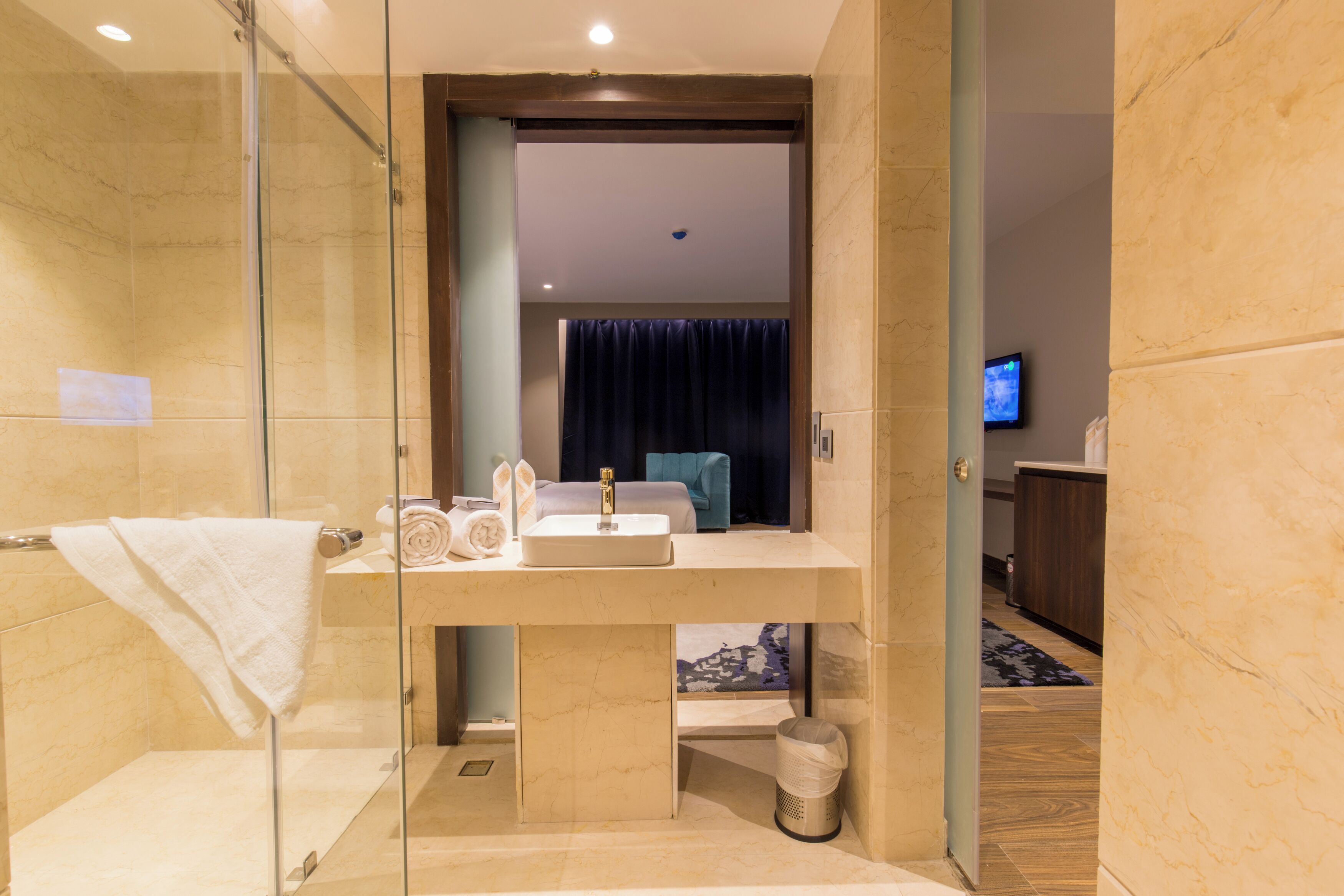 A modern bathroom with a glass-enclosed shower, a sink with a mirror, and a towel rack.
